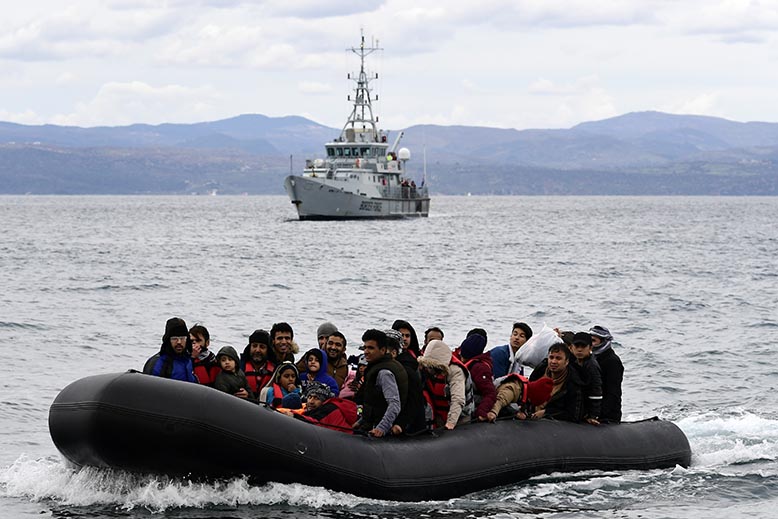 Migranter i Grekland, åtföljda av Frontex. Foto: AP/TT