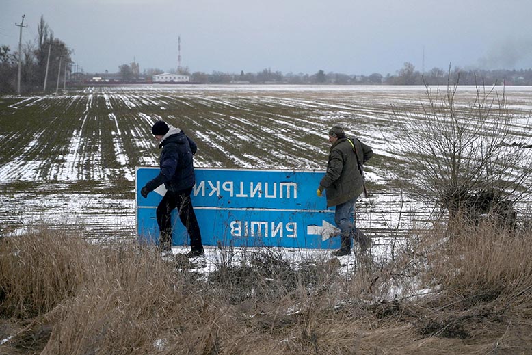 Vägskylt utanför Kiev tas bort för att förvilla rysk militär. Foto: Reuters/TT