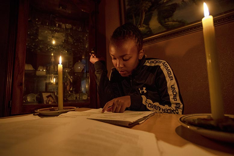 Ndofhiwa Mabasa i Vosloorus öster om Johannesburg tvingas läsa sina läxor i skenet från stearinljus under ett av otaliga strömavbrott. Foto: Themba Hadebe/AP/TT