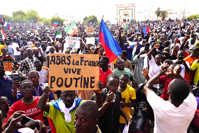 "Ner med Frankrike, leve Putin", står det på plakatet under en demonstration i Niger i anslutning till kuppen. Foto: Sam Mednick/AP/TT