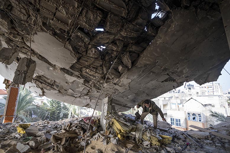 En man letar ägodelar efter bombning i Rafah. Foto: AP/TT