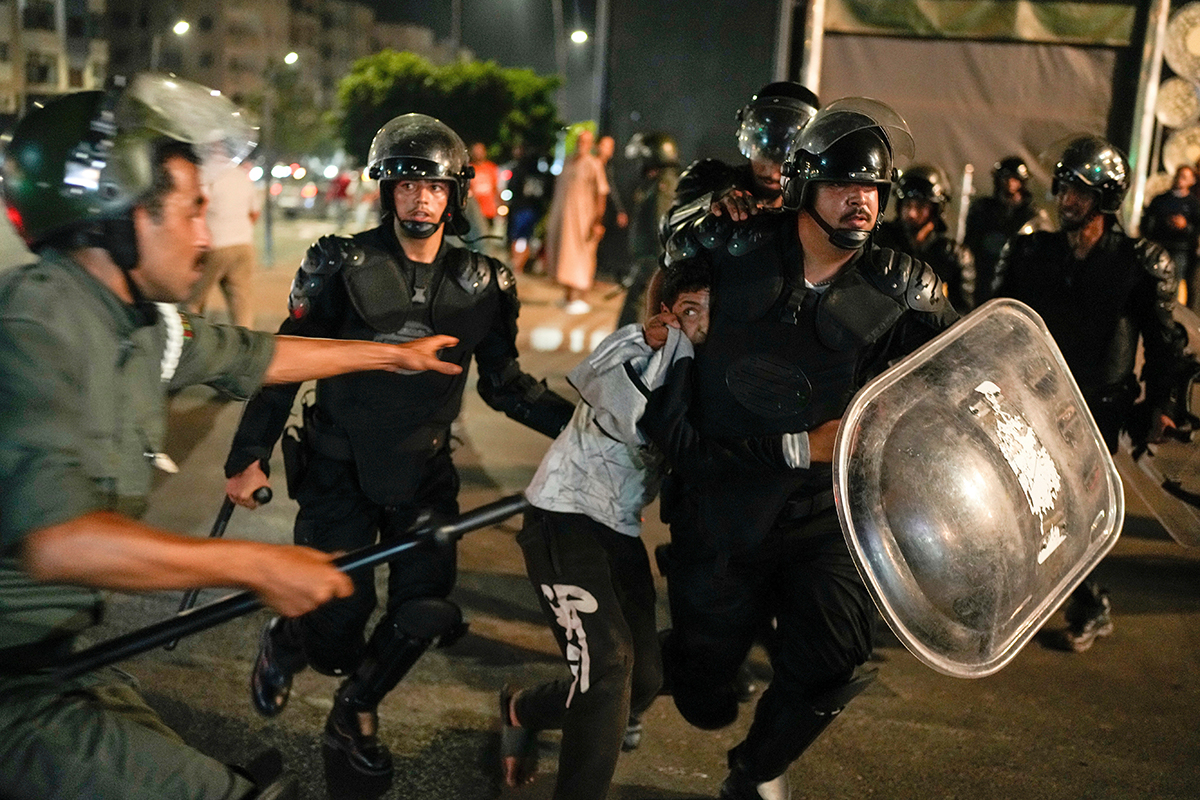 Unga driver på. En pojke grips i Sale i Marocko under en protest. Foto: AP/TT